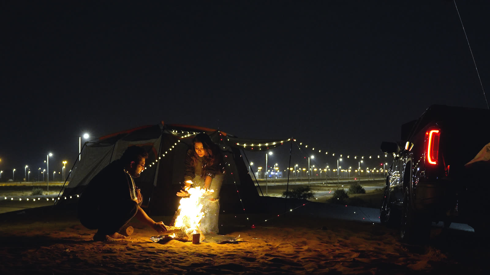 Vibha and Jishnu by the campfire at night